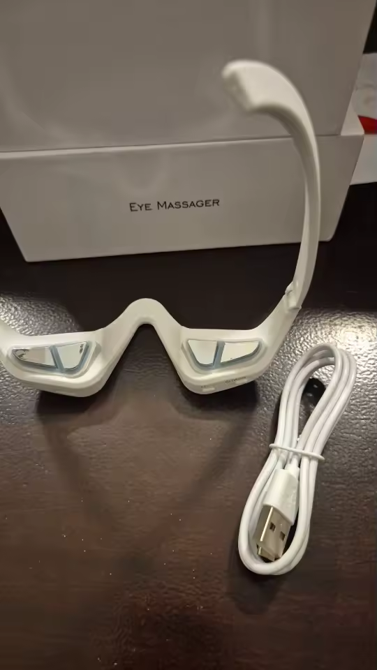 Eye Massager with cable and box on the table